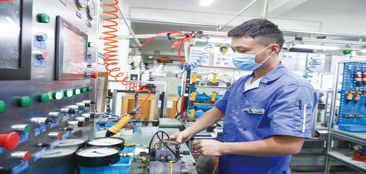 日前在展拓液压(上海)有限公司生产车间内  工人正在阀类试验生产线上